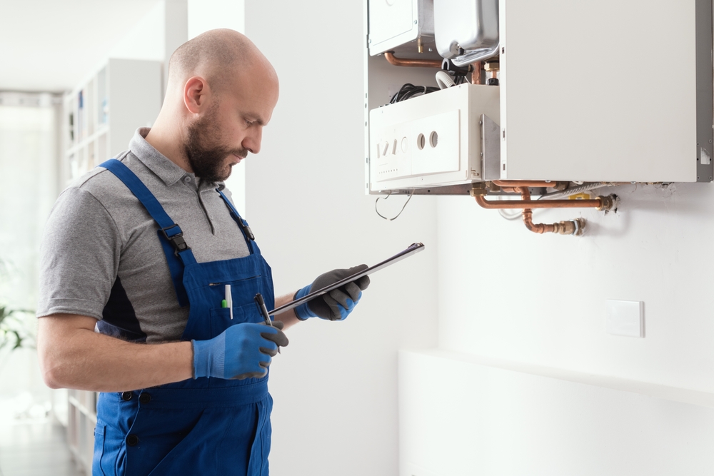 Gas engineer writing a gas safety certificate